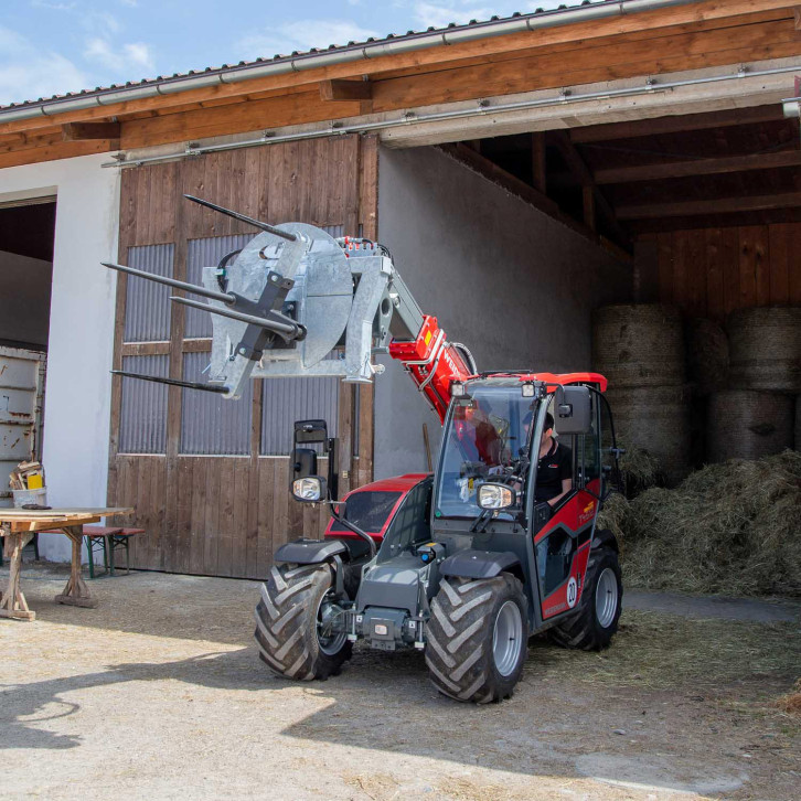Round bale unwrapping and transport attachment 